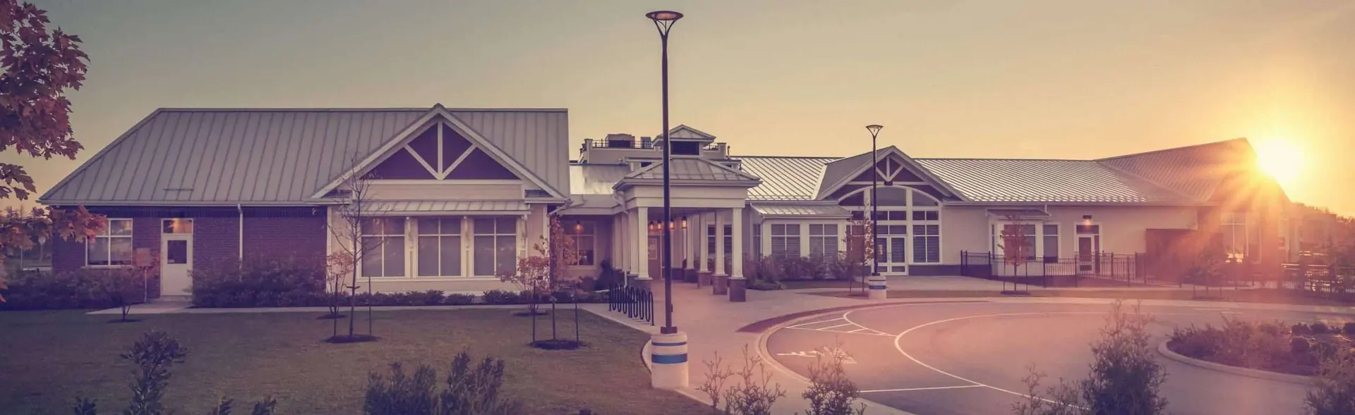 A long single-storey commercial building with a new roof at sunset