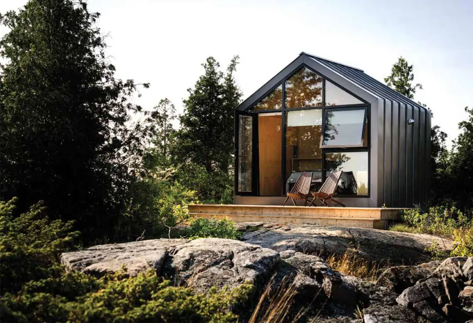 Black metal cabin on a rocky outcrop