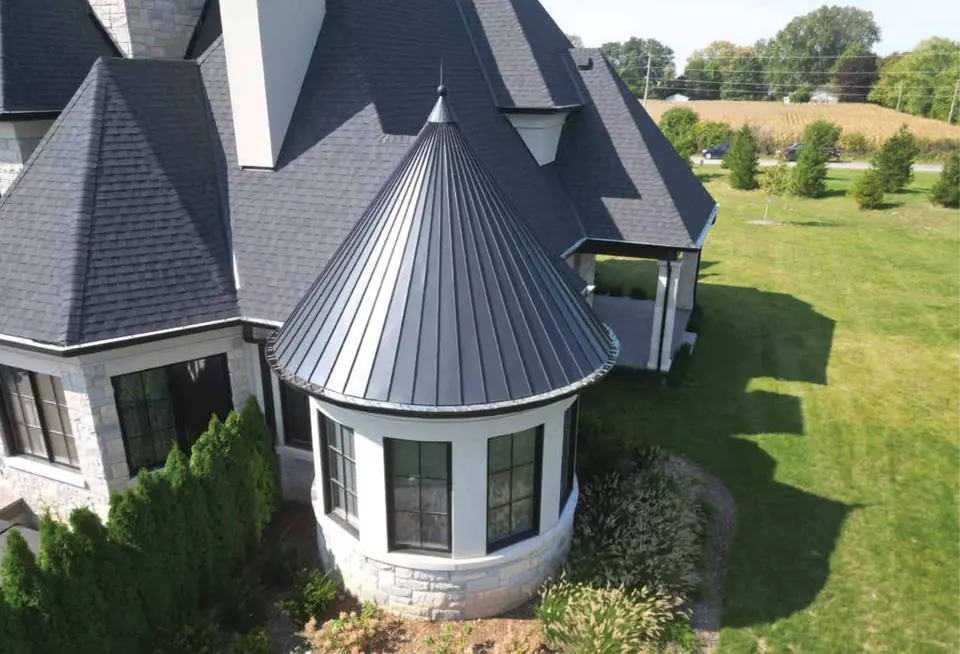 Turret with a metal cone roof on a stone home