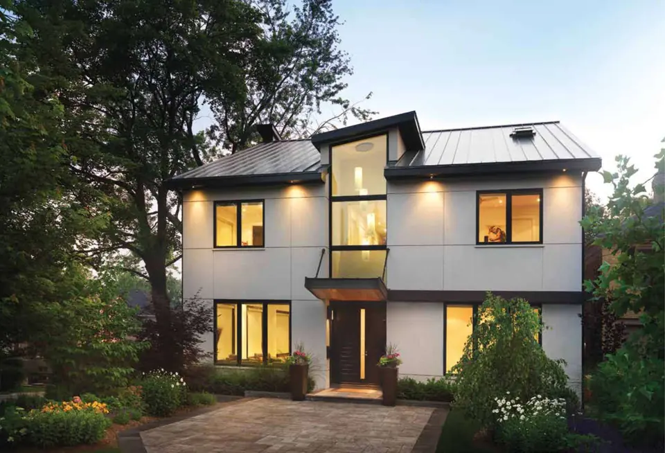 Modern white home with a metal roof at dusk