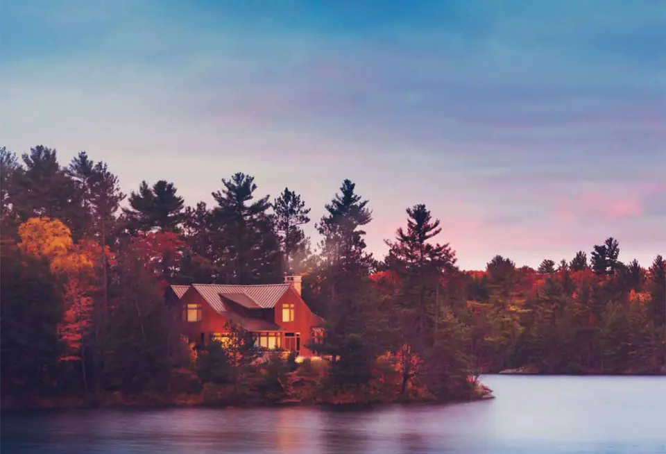Waterfront home at sunset with a metal roof