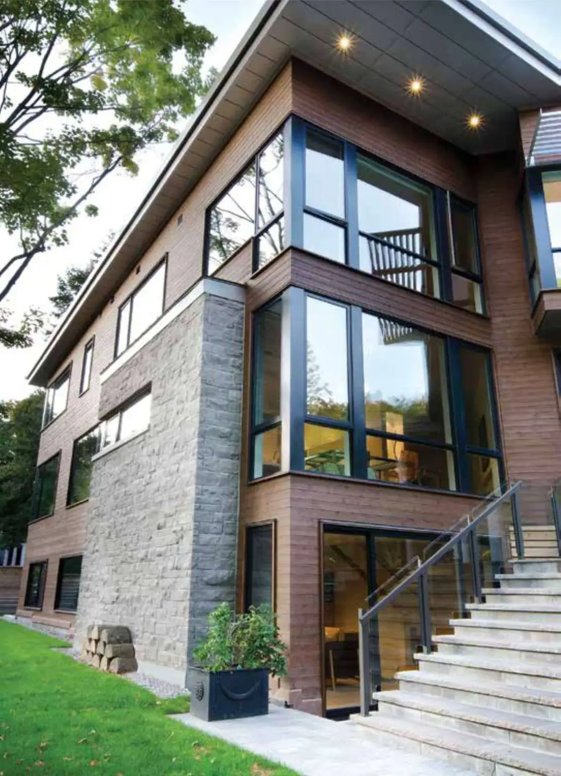 Contemporary stone and glass home with a cantilevered upper storey