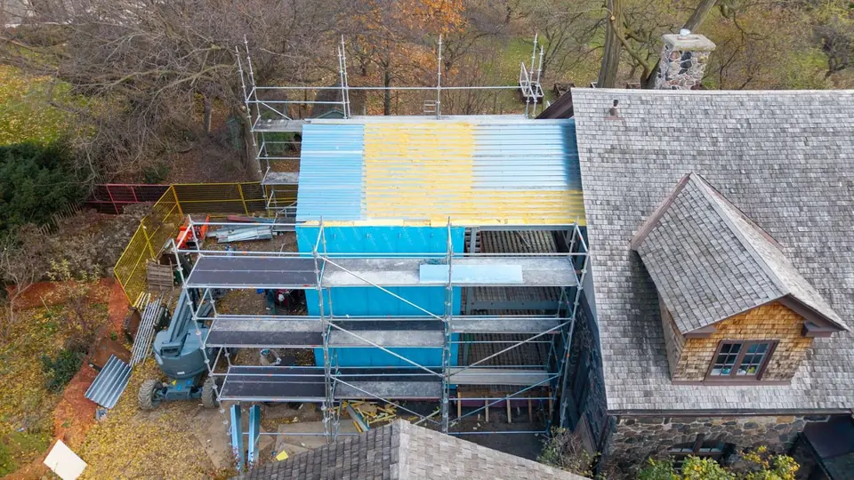 Close aerial of the scaffolded wing with weather barrier installed
